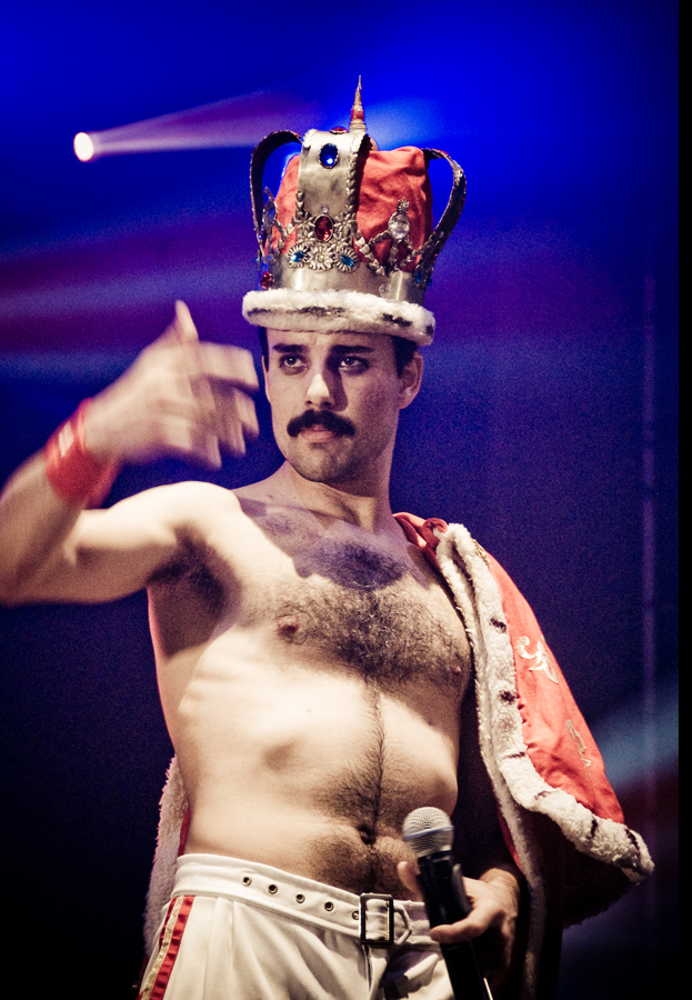 Photo of Freddie Mercury wearing a crown on stage.