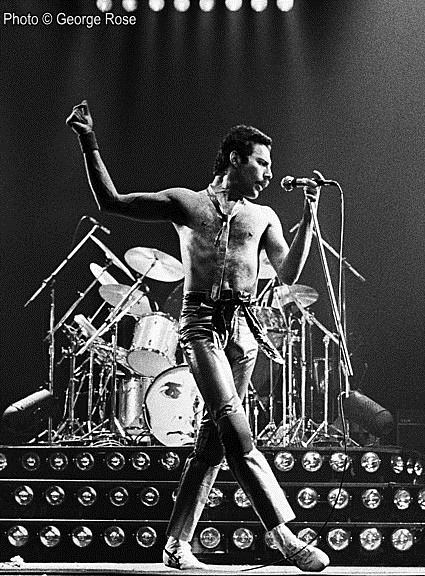 Black and white photo of Freddie Mercury on stage.